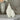 White religious statue of Mary and a crown of stars in two different sizes on a lace tablecloth
